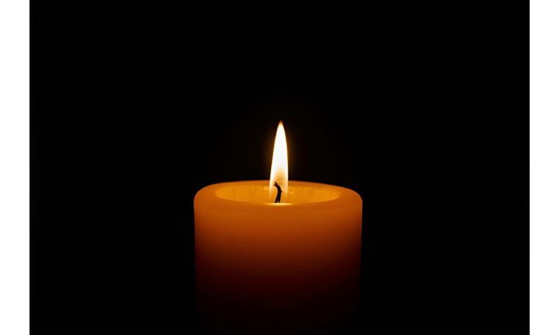 paląca się świeca na czarnym tle